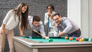 Ofis tatilinde bilardo oynayan neşeli iş adamları.