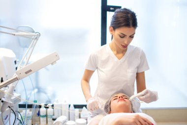Genç bir kadın güzellik salonunda hidrakiyal terapi görüyor.