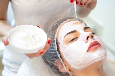 Yüz soyma maskesi, kaplıca güzellik tedavisi, cilt bakımı. Güzellik salonundaki kadın yüz bakımını alıyor. Yan görüş, yakın çekim..