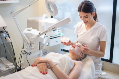 Güzellik uzmanı spa 'da kadın yüzüne enzimsel soyma uyguluyor..