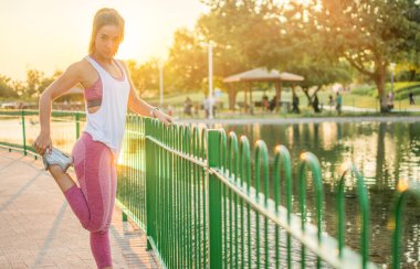 Genç fitness kadını gün batımında dışarı çıkıyor.