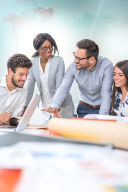 Mühendislerden oluşan bir ekip modern ofiste toplantının planını tartışıyor.