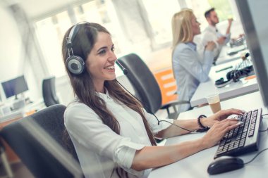 Çağrı merkezinde kulaklığı olan gülümseyen kadın yardım hattı operatörü