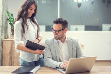 Genç iş adamları ofiste belgeleri tartışıyor