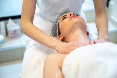 Genç kadın güzellik salonunda dekolte masajı yaptırıyor.