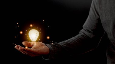 Ampulü tutan el. Yenilikçi ve ilham verici bir fikir. Elinde ampul ışığı çizimi fikri
