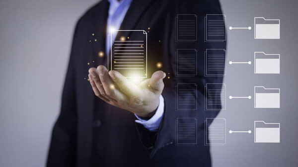 Document Management System (DMS) being setup by IT consultant working on laptop computer in office. Software for archiving, searching and managing corporate files and information