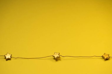 stars on a wire on a yellow background.top view