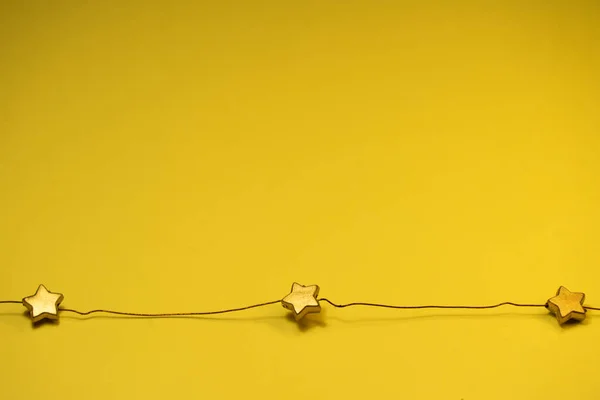 stars on a wire on a yellow background.top view