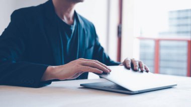 businessman open or close computer laptop , concept of success finished deal or job, man working on white wood table in office.
