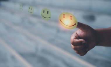 Customer service satisfaction survey concept.Business people or customers show satisfaction by thumb up on face emoticon smile in satisfaction on virtual touch screen.	
