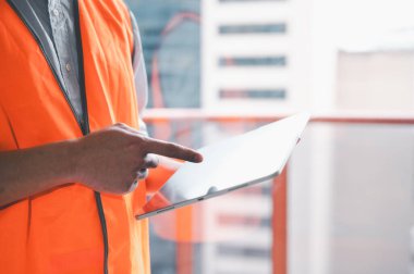 işçi, ustabaşı ya da inşaatçı çelik yelek ya da güvenlik gömleği giyip