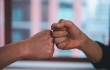 İki adam diğer elin yumruklarıyla çarpıştı. Yüzleşme konsepti, iş anlaşması sözleşmesi, başarı pazarlığı, karşılama ortağı veya arkadaşlık, el işi işbirliği önerisi