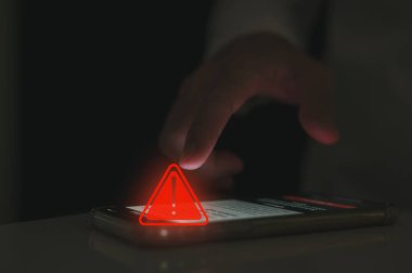 Risk ve bilgilendirme hatası ve bakım konsepti, üçgen uyarı işareti olan akıllı telefon kullanan kullanıcı, hacker saldırıları ve hack verileri, siber suçlar, siber güvenlik, Fidye yazılımı, Phishing