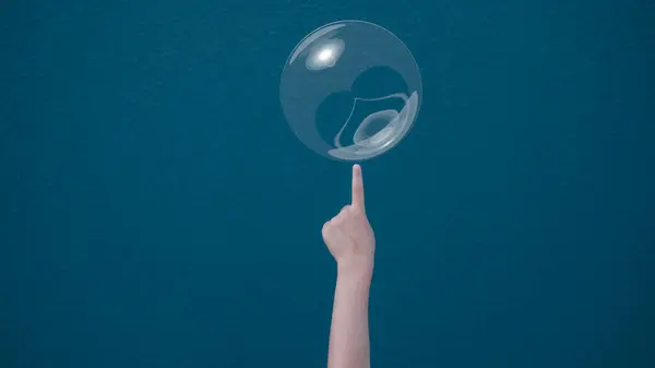 Risk management concept kid finger pointing or pricking to soap bubble floating on air. Risk, danger, fragility concept