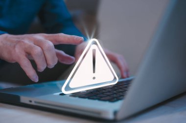 İnternet ağındaki risk ve siber güvenlik. İş adamı, uyarı üçgeni uyarı işaretli bilgisayar klavyesi kullanıyor. Uyarı hatası ve bakım kavramı için.