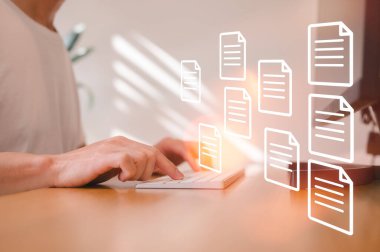 Elektronik belge ikonları, E-belge yönetimi, çevrimiçi belge veritabanı, kağıtsız ofis kavramı ile bilgisayar klavyesinde yazan işadamı