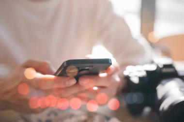 Sosyal medya pazarlama kavramı. Akıllı telefon yazma, sohbet kutusu simgeleriyle sohbet eden erkek eli kafeteryadaki sosyal medyayı kontrol edip rahatlatıcı bir inleme sesi çıkarıyor.