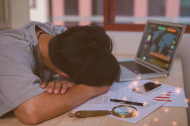 İşte ya da ofis masasında uzun bir günün stresi altında çalışan ofis sendromlu adam, aşırı çalışmaktan muzdarip olarak ofiste şekerleme yapıyor.