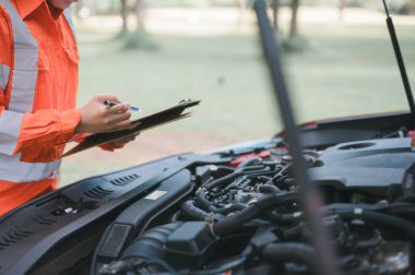 Araba servisi ve kontrol konsepti. Bakım listesi aracı için tableti tutan bir tamircinin eli, Müşteri hizmetleri konsepti araba teknisyeni SOH 'un akü durumunu kontrol ediyor