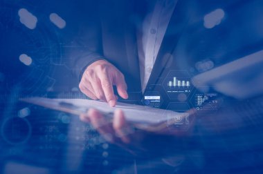 Veri analizi ve iş büyüme stratejisi kavramına ilişkin sanal çizelgeler içeren pano ve kağıt veri raporları tutan işadamı