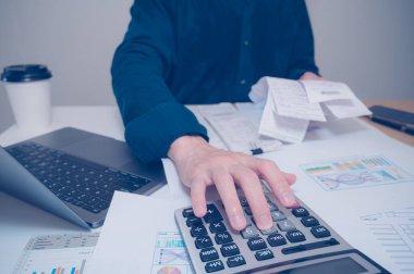 İş adamlarının el ile hesaplama bütçe kontrol faturalarını kapatması, ev bütçesi yönetimini hesaplamak için hesap makinesini kullanması. Finans, bütçe ve vergi hesaplamaları, aylık giderler
