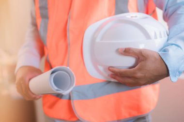 Bir mühendis ya da ustabaşı inşaat planlarını planlayan mühendis mimar, baret ve taslak üzerinde çalışıyor.