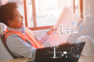 İnşaatta çalışan bir mühendis ya da ustabaşı kağıt planına ya da planına bakıyor.