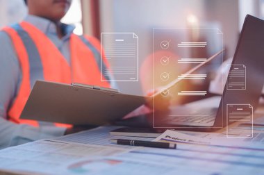 Site üzerinde çalışan bir mühendis veya ustabaşı kağıt pano ve sanal belge simgesini site okuma veya imzalama belgesi üzerinde çalışır.