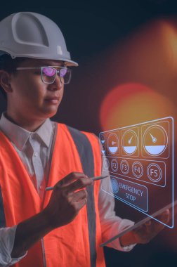 Gözlük, turuncu yelek ve dijital tablet taşıyan mühendis sanal makine veya bitki diyagramına bakıyor