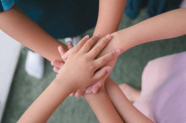 Arkadaş canlısı bir aile el ele tutuşuyor. El ele tutuşmalar, el ele tutuşmalar, çocuklar birlik, destek ve dostluk için, kızlar takım çalışması için el ele tutuşuyor.