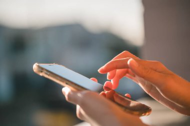 Sosyal medya pazarlama konseptinde el ele tutuşan akıllı telefon. Sohbet kutusu simgelerinde akıllı telefon yazma, sohbet etme kullanılıyor.