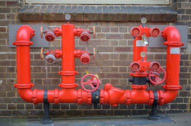 Kırmızı borularla yangın söndürme sistemi. Yangın söndürme sistemindeki ana su boruları. Yangın söndürme. Yangın söndürme sisteminin elle vanası.