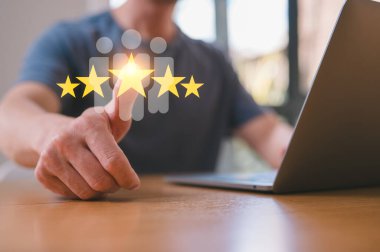 Takım çalışması ve geri bildirim Müşteri memnuniyeti anketi. İş adamı, müşteriler sanal dokunmatik ekranda tatmin olmak için başparmağıyla beş yıldız çubuğundan memnuniyet gösteriyor.