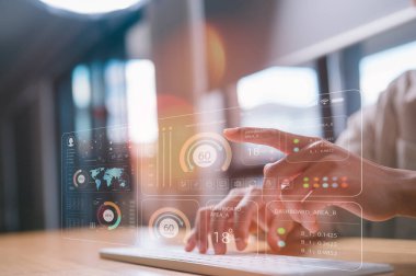 İnsan elleri kablosuz bilgisayar klavyesinde yazarken bir analist veri iş analizi ve KPI ve metrik veri yönetimi sistemi için bir bilgisayar ve panel kullanır