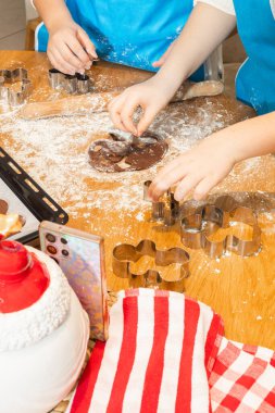 Anne ve kızın hamuru yuvarlarken ve mutfakta kurabiye keskisi kullanırken en iyi görüntü. Un, yemek tepsisi, ev yapımı kurabiyeler. Kavram: Aile, bağ, yaratıcılık