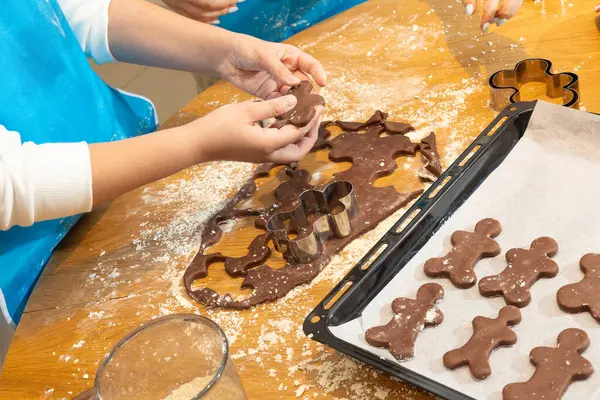 Anne ve kızın hamuru yuvarlarken ve mutfakta kurabiye keskisi kullanırken en iyi görüntü. Un, yemek tepsisi, ev yapımı kurabiyeler. Kavram: Aile, bağ, yaratıcılık