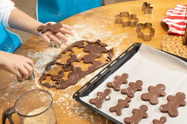 Anne ve kızın hamuru yuvarlarken ve mutfakta kurabiye keskisi kullanırken en iyi görüntü. Un, yemek tepsisi, ev yapımı kurabiyeler. Kavram: Aile, bağ, yaratıcılık
