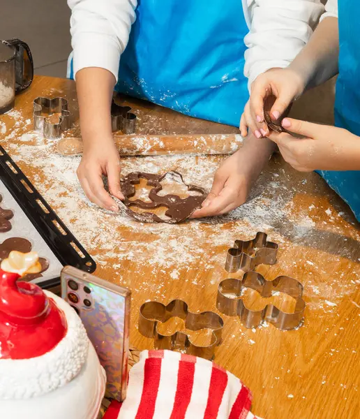 Anne ve kızın hamuru yuvarlarken ve mutfakta kurabiye keskisi kullanırken en iyi görüntü. Un, yemek tepsisi, ev yapımı kurabiyeler. Kavram: Aile, bağ, yaratıcılık