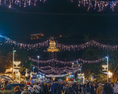 HAIFA, ISRAEL 10 ARALIK 2023: Ben Gurion Bulvarı 'nın arka planda kalabalıklar ve Bah Tapınağı ile süslenmiş gece manzarası