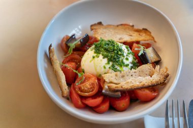 Kiraz domatesli gurme burata salatası manzarası. Sebze ve İtalyan peynirini vurgulayan sağlıklı ve protein zengini bir yemek.