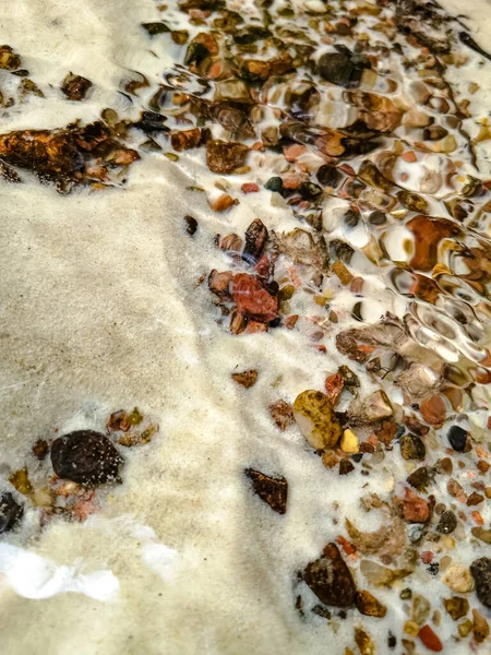 Small colourful pebbles in the bottom of a small stream