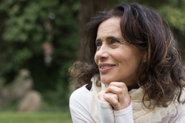 Orta yaşlı, iyimser bakışlı, parkta elleri üzerinde dinlenen hoş bir bayan. Vizyoner kadın, girişimci hayal gücü, düşünceli, özgürlük, emeklilik planları