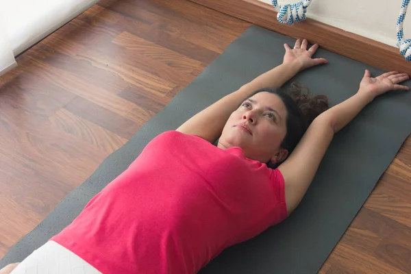 Young Female Yogi Lying Mat Stretching Back Arms Head Yoga — Foto de Stock