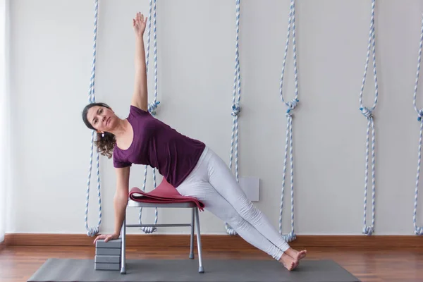 Female Yoga Student White Leggings Purple Shirt Leans Heap Chair — Stok fotoğraf