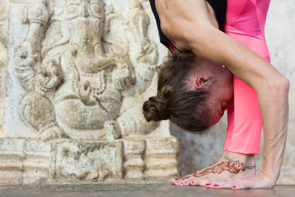 Woman Pink Leggings Practicing Yoga Ganesha Sculpture Head Her Legs — Stock Photo, Image