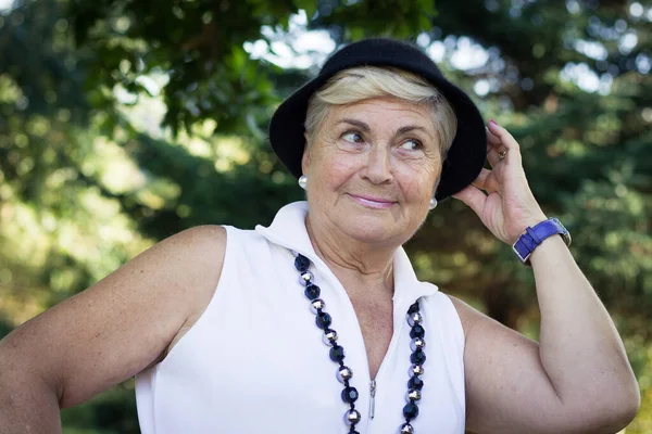 Pretty Elder Blonde Woman Posing Hand Holding Black Hat Park — Stockfoto