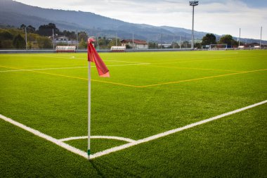 Yeşil çim futbol sahasında kırmızı bayrak sallanıyor. Futbol Dünya Kupası konsepti