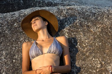 Güzel model kadın Rock 'ın yanında dinleniyor. 