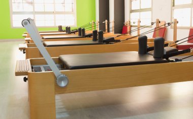Parlak stüdyodaki pilates ahşap reformcuları. Spor salonu, egzersiz ekipmanı konseptleri.